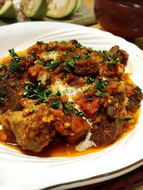 鹿の赤ワイン煮込みを器に盛る