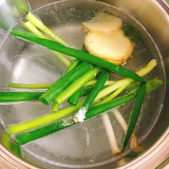 湯にネギと生姜を加えます