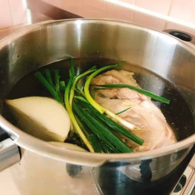 鶏ガラと野菜を圧力鍋に入れる