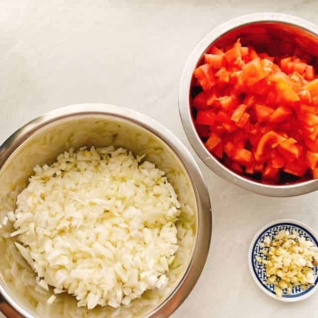玉ねぎ、ニンニク、トマトを切ります